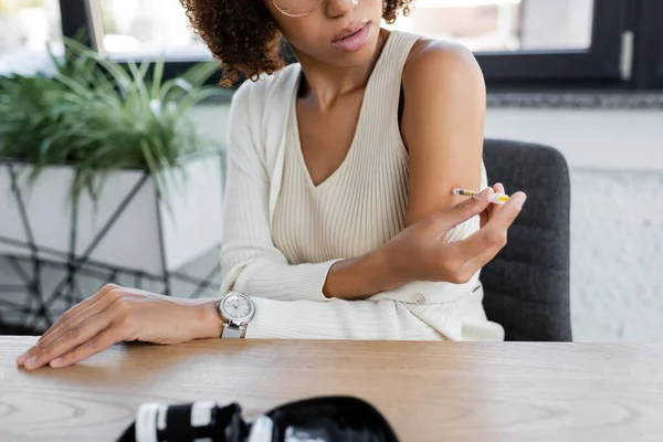 Обрезанный взгляд на африканскую американскую деловую женщину, делающую инъекции инсулина рядом с набором диабета — стоковое фото
