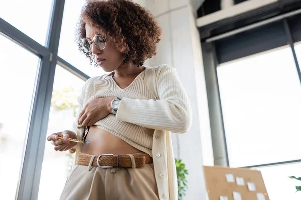 Low angle view of african american businesswoman with diabetes doing insulin injection in belly in office — Stock Photo