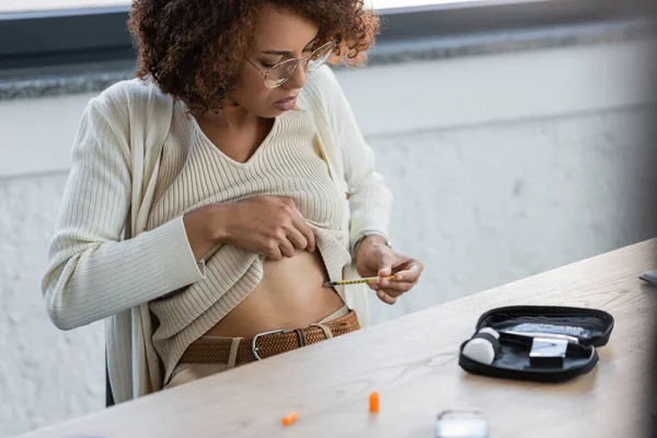 Africano americano mulher com diabetes fazendo injeção de insulina perto de kit médico no escritório — Fotografia de Stock