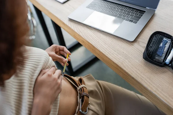Cropped view of african american businesswoman doing insulin injection near diabetes kit and working table in office — Stock Photo