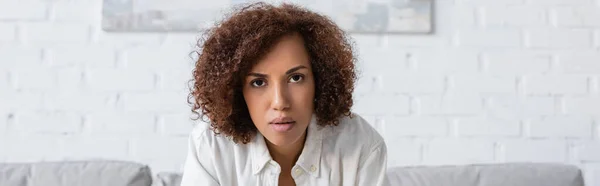 African american woman in shirt looking at camera at home, banner — Stock Photo