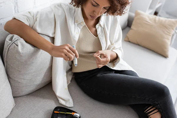 Молода американка з діабетом перевіряє інсулін, тримаючи вдома перо для лінкетів. — стокове фото