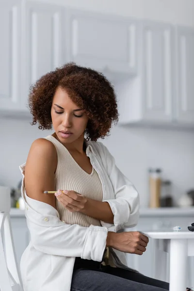 African american woman with diabetes doing insulin injection near lancet pen in kitchen — Stock Photo
