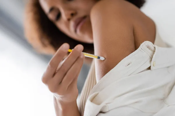 Low angle view of african american woman with syringe doing insulin injection at home — Stock Photo