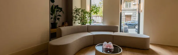 Modern sofa and coffee table near green plants in luxury hotel, banner — Stock Photo