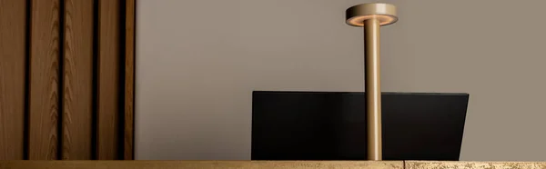 Computer monitor near modern golden lamp on reception of luxury hotel, banner — Stockfoto