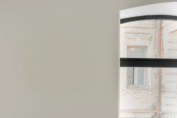 Grey wall next to window with view on aged building from hotel — Stock Photo