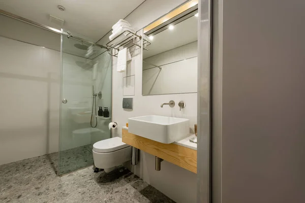 Интерьер современной белой ванной комнаты с раковиной и туалетом — стоковое фото