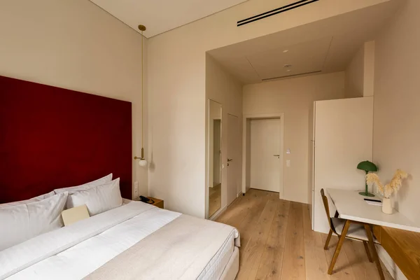 Дерев'яний стілець біля робочого простору і ліжко в номері готелю — стокове фото