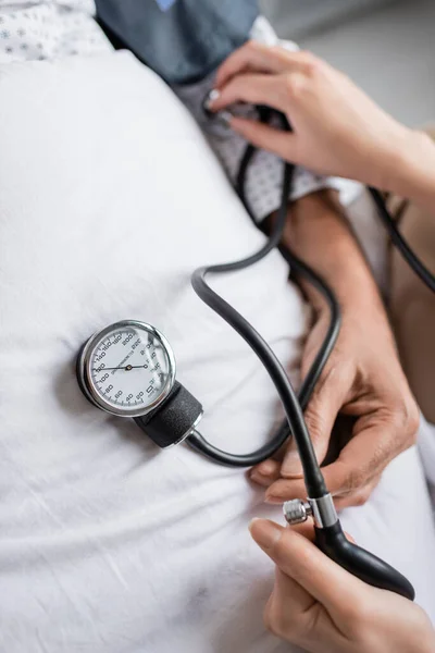 Draufsicht des Arztes mit Tonometer auf kranken Patienten am Krankenbett — Stockfoto