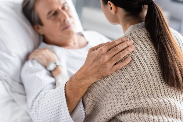 Blurred elderly patient hugging daughter in hospital ward — Stock Photo