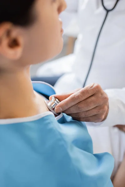 Cropped view of blurred doctor checking lungs of patient in hospital — Stock Photo