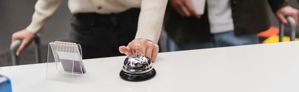 Cropped view of woman ringing service bell near card holder on hotel reception, banner - foto de stock