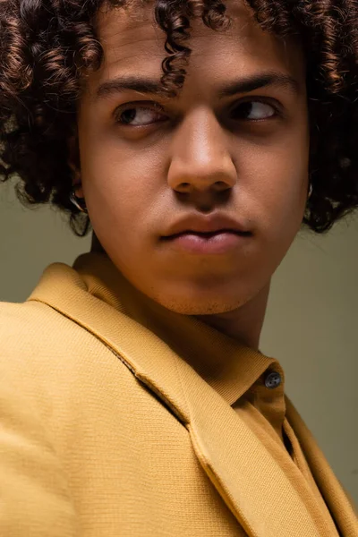 Close up portrait of young african american man in yellow clothes looking away isolated on grey — Stockfoto