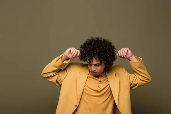 Giovane ragazzo afroamericano con i capelli ondulati in posa in camicia gialla e blazer su sfondo grigio — Foto stock