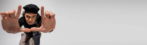 Trendy african american man in black beret and scarf showing snapshot gesture on grey background, banner — Stock Photo