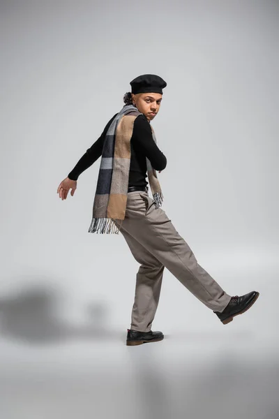 Full length of young african american man in fashionable casual attire looking at camera while posing on grey background — Photo de stock