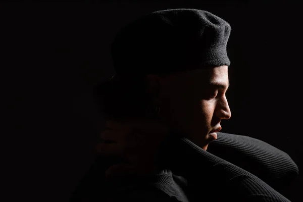 Profil eines jungen afrikanisch-amerikanischen Mannes in stylischem Barett und Rollkragen isoliert auf schwarz — Stockfoto