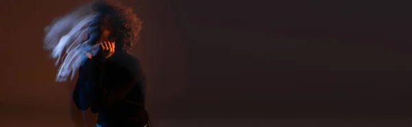Движение размытие кудрявый африканский американец с биполярным расстройством на темном фоне с синим и оранжевым светом, баннер — стоковое фото