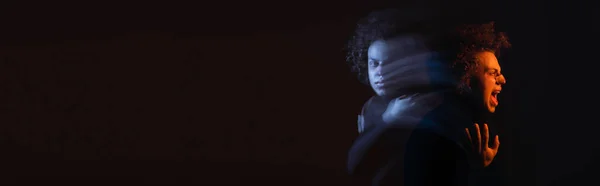 Double exposure of wounded african american man with bipolar disorder screaming on dark background with orange and blue light, banner - foto de stock