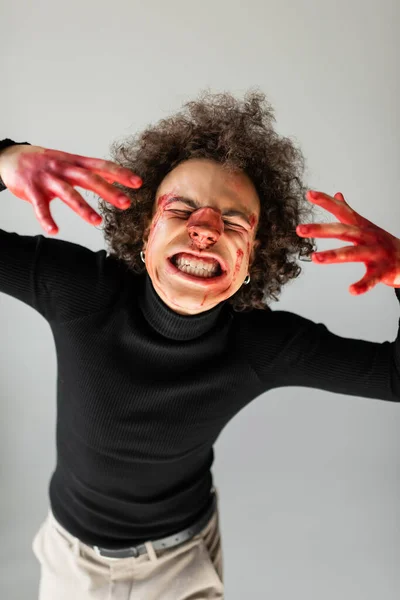 Abused and injured african american man with bleeding face and broken nose grimacing isolated on grey — Fotografia de Stock