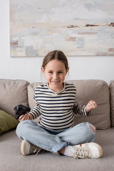 KYIV, UKRAINE - NOVEMBER 28, 2022: cheerful kid holding joystick while playing video game — Stockfoto