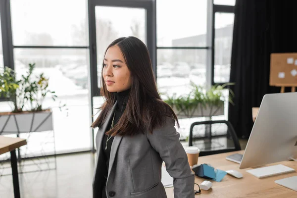 Young asian designer in jacket standing in design studio — Stock Photo