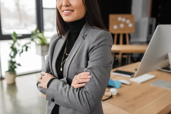 Обрізаний вид усміхненого дизайнера інтер'єру, що перетинає руки в офісі — стокове фото