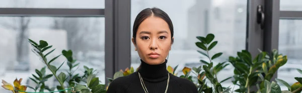 Young asian interior designer looking at camera in studio, banner — Stock Photo