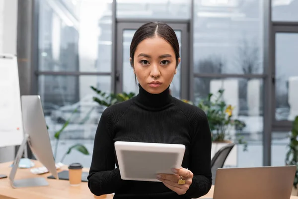 Portrait of asian designer looking at camera and holding digital tablet in studio — Stock Photo
