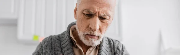 Depressed grey haired man with alzheimer syndrome looking down at home, banner — Stock Photo