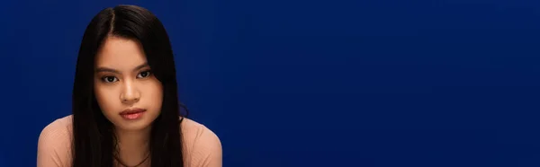 Young asian woman looking at camera isolated on blue with copy space, banner — Stock Photo