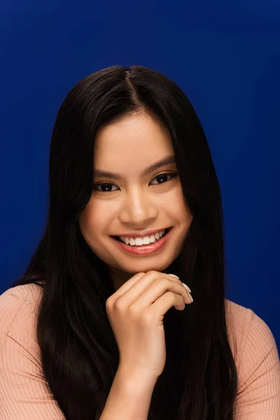 Portrait of happy young asian woman looking at camera isolated on blue — Stock Photo