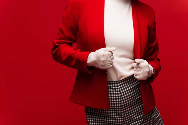 Cropped view of stylish woman in gloves touching jacket isolated on red — Foto stock