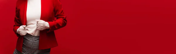 Cropped view of woman in gloves touching blazer isolated on red, banner — Foto stock