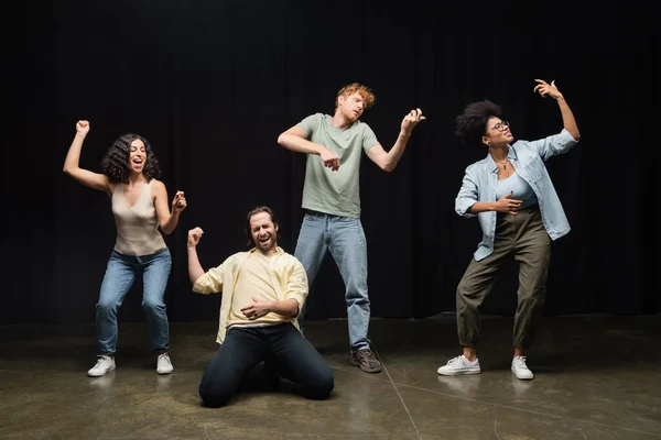 Full length of young multicultural students rehearsing in various poses in acting skills school — Foto stock