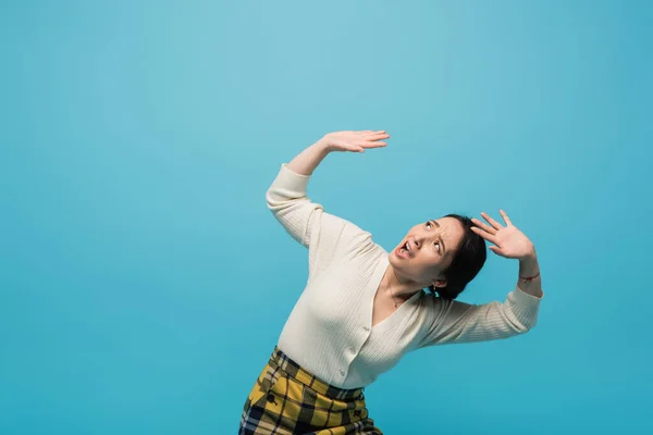 Scared asian woman looking up isolated on blue — Fotografia de Stock