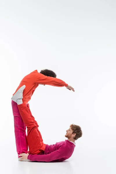 Interracial couple in magenta color clothes showing c letter on white background - foto de stock