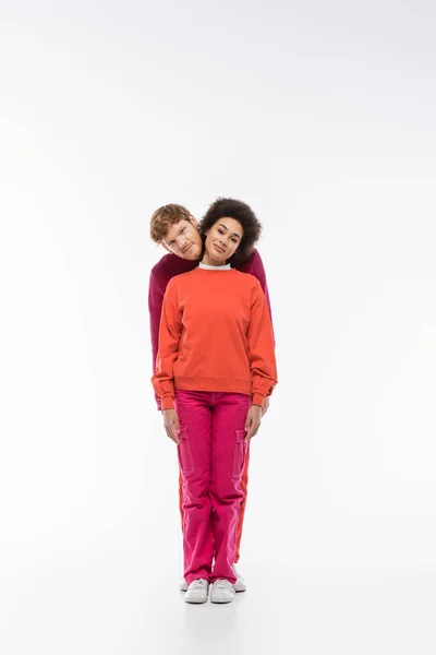 Весёлая межрасовая пара в пурпурной цветовой одежде, показывающая i букву на белом фоне — стоковое фото