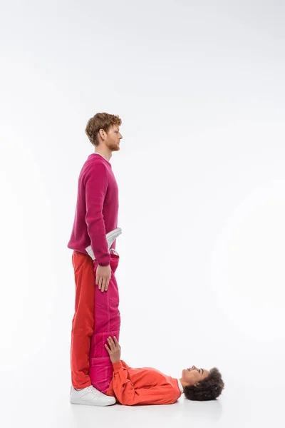 Side view of interracial couple in magenta color clothes showing L letter on white background — Stock Photo