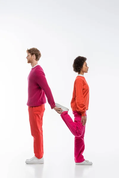 Side view of interracial couple in magenta color clothes showing n letter on white background — Foto stock
