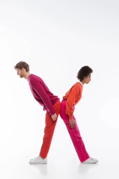 Side view of interracial couple in magenta color clothes showing x letter on white background — Stock Photo