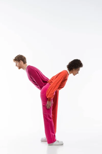Side view of interracial couple in magenta color clothes showing y letter on white background — Stock Photo