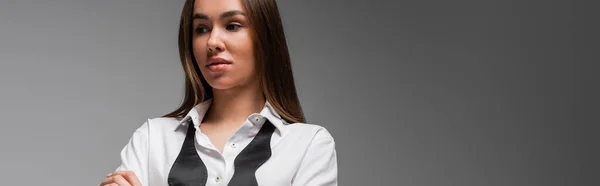 Portrait of confident woman in white shirt and black tie looking away isolated on grey, gender equality concept — Stock Photo