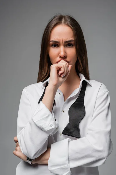 Portrait of doubtful woman in white shirt and black tie isolated on grey — Stock Photo
