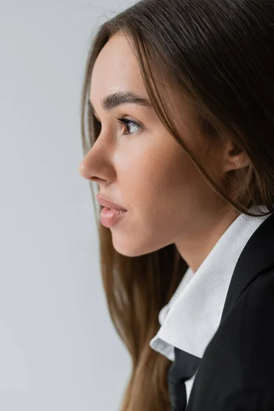 Side view of pretty woman with brunette hair looking away isolated on grey — Stock Photo