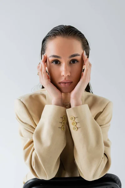Hübsches Model in beige stylischem Blazer mit Blick auf Kamera isoliert auf grau — Stockfoto