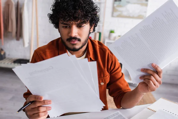 Focused indian copywriter working with papers at home — Stock Photo