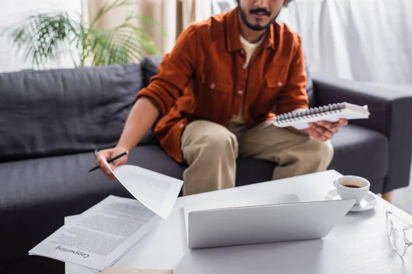 Cropped view of indian copywriter working with papers and notebook at home — Stock Photo