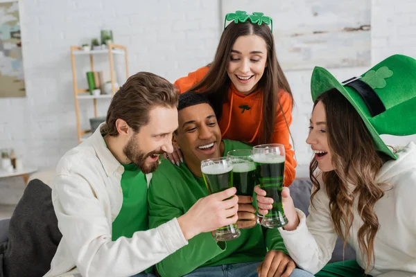 Позитивные многонациональные друзья звонят в зеленое пиво в день святого Патрика — стоковое фото